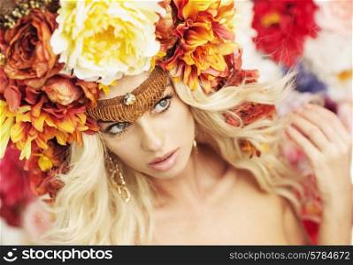 Portrait of the serious blonde wearing huge colorful wreath