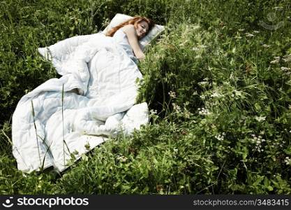 Portrait of the sleeping young woman on a meadow