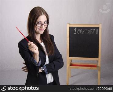 Portrait of the teacher. In the hands of the teacher&#39;s pointer. The teacher in the background stands the Board where it is written on September 1