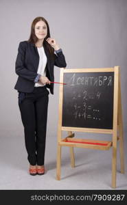 Portrait of the teacher. Master standing with a pointer at the Board and point at it. On the Board&#39;s written on September 1 and example.