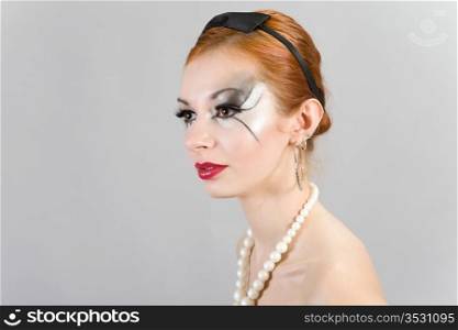 Portrait of the young attractive girl with a theatrical make-up