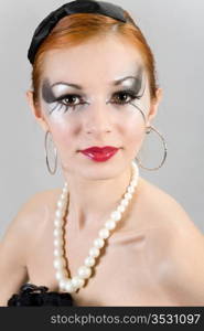 Portrait of the young attractive girl with a theatrical make-up