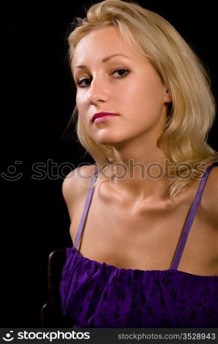 Portrait of the young attractive woman on a black background