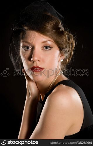 Portrait of the young attractive woman on a black background