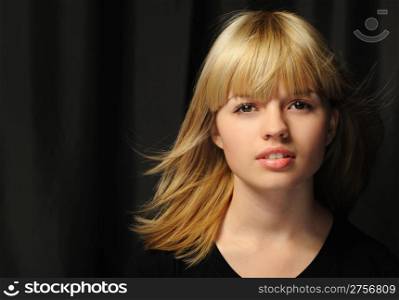 "Portrait of the young attractively girl. Hair of "wheaten" color. A dark back"