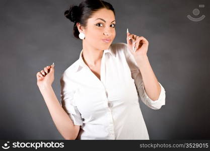 Portrait of the young beautiful brunette against a dark background with illumination