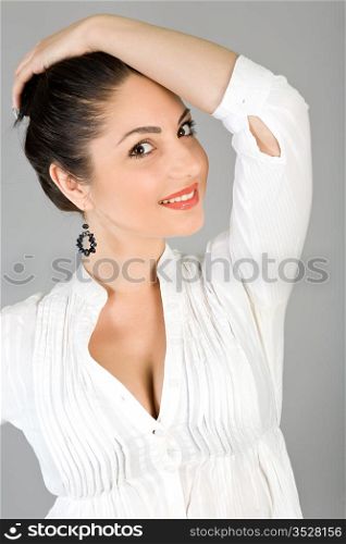 Portrait of the young beautiful brunette on a gray background