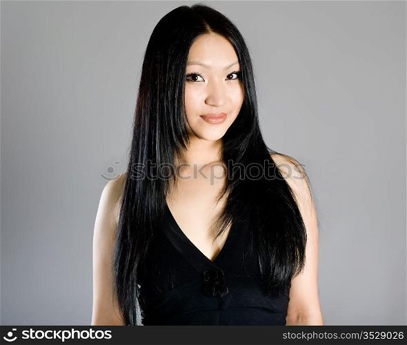 Portrait of the young beautiful brunette on a grey background