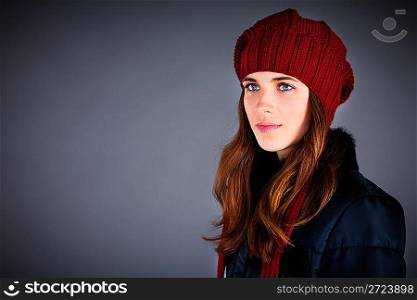 Portrait of the young girl in a winter cap on the dark