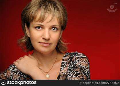 Portrait of the young girl on a red background. The European appearance