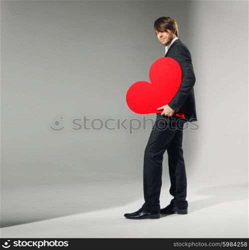 Portrait of the young guy holding heart