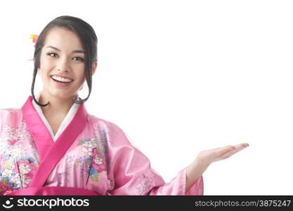 Portrait of the Young Japanese Woman Wearing a Traditional Kimono Dress and Showing Something at the White Background. Waist Up