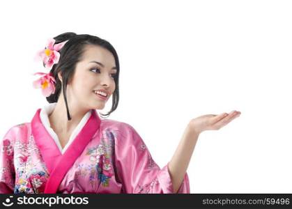 Portrait of the Young Japanese Woman Wearing a Traditional Kimono Dress and Showing Something at the White Background
