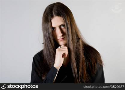 Portrait of the young man with long hair in black clothes
