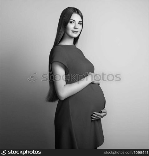 Portrait of the young pregnant woman. Pregnancy, love, people and expectation concept. Happy pregnant lady with long hair. Black and White photo