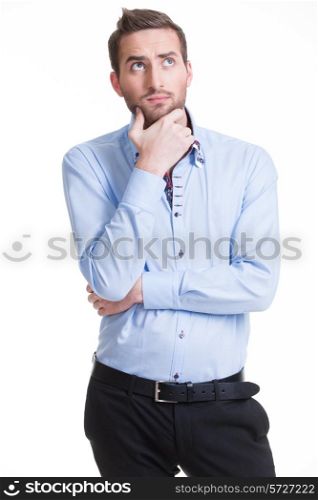 Portrait of the young thinking man looks up in casuals isolated on white background.