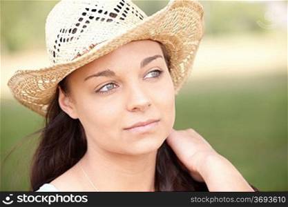 portrait of thoughtful attractive young woman wearing straw hat