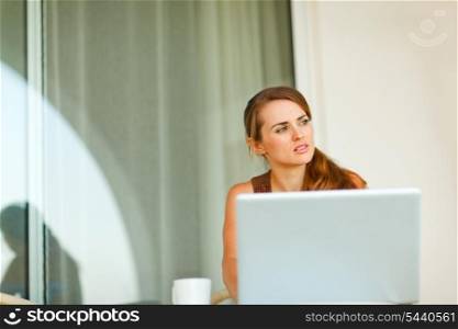 Portrait of thoughtful beautiful woman working on laptop&#xA;