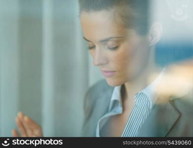 Portrait of thoughtful business woman leaning on window