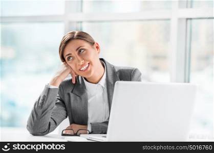 Portrait of thoughtful business woman working on computer at office and resting her head on hand