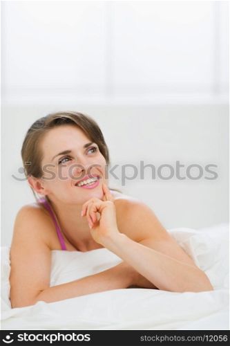 Portrait of thoughtful girl laying on bed