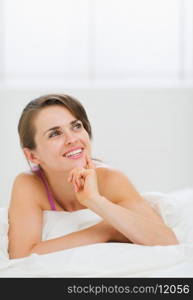 Portrait of thoughtful girl laying on bed