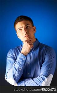 Portrait of thoughtful man against blue background