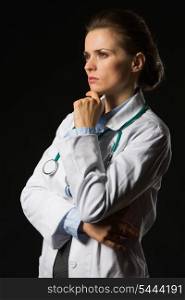 Portrait of thoughtful medical doctor woman looking on copy space isolated on black