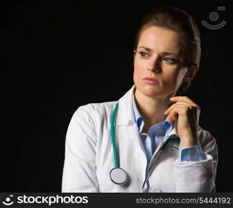 Portrait of thoughtful medical doctor woman looking on copy space isolated on black