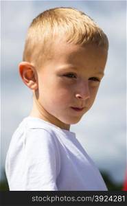 Portrait of thoughtful pensive little boy child kid outdoors