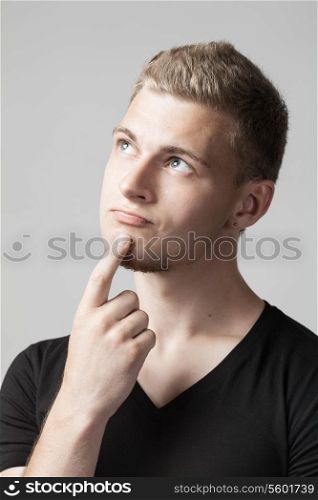 portrait of thoughtful young caucasian man isolated on gray background