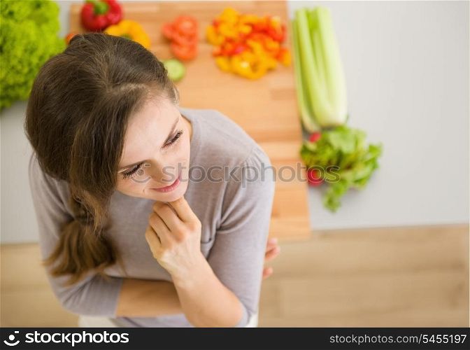 Portrait of thoughtful young woman in kitchen