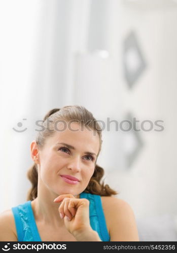 Portrait of thoughtful young woman in living room