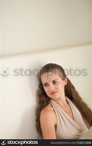 Portrait of thoughtful young woman sitting on couch