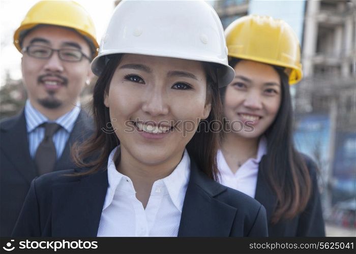 Portrait of three architects wearing hardhats, Beijing