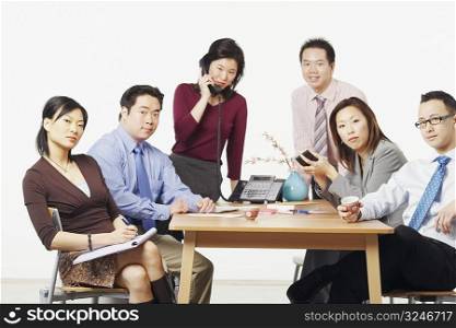 Portrait of three businessmen and three businesswomen in a meeting