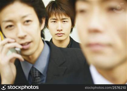 Portrait of three businessmen one behind the other