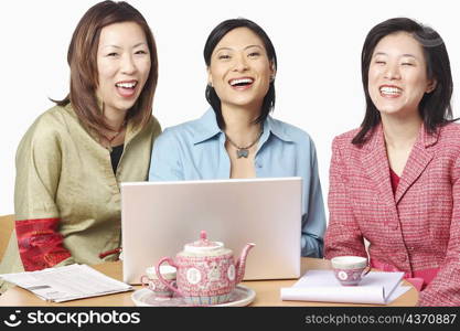 Portrait of three businesswomen in front of a laptop