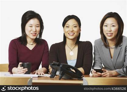 Portrait of three businesswomen sitting and smiling