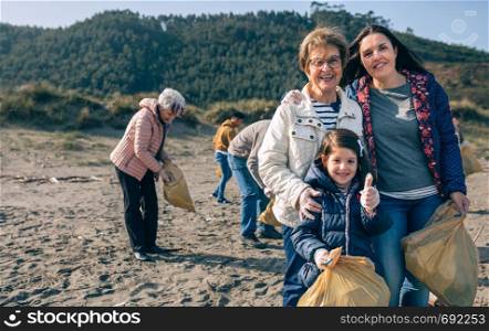 Portrait of three female generations of female volunteers cleaning the beach. Female volunteers cleaning the beach