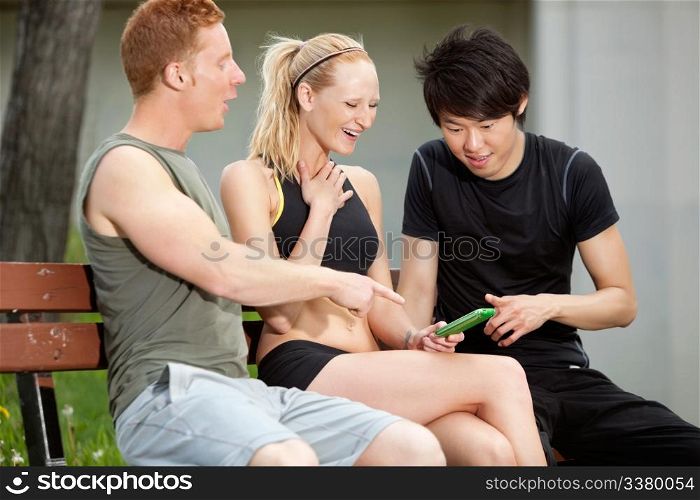 Portrait of three friends playing around with a mobile phone