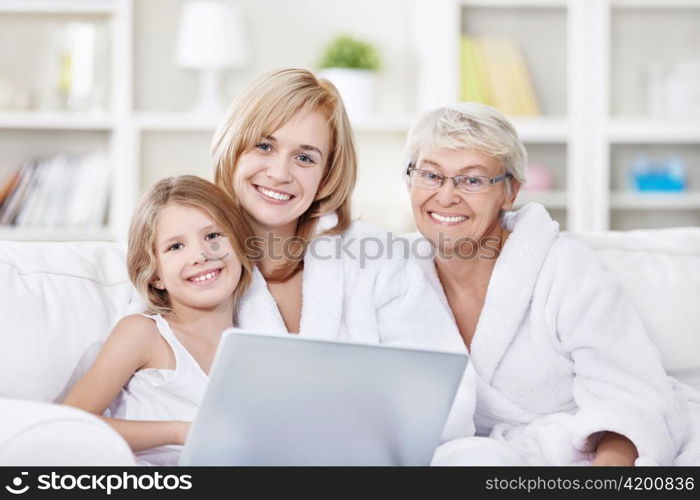 Portrait of three generations of women with a laptop