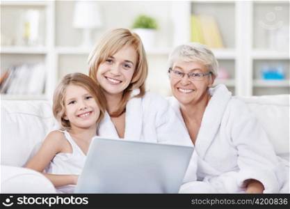 Portrait of three generations of women with a laptop