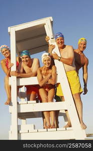 Portrait of three mature men and two mature women on a lifeguard chair