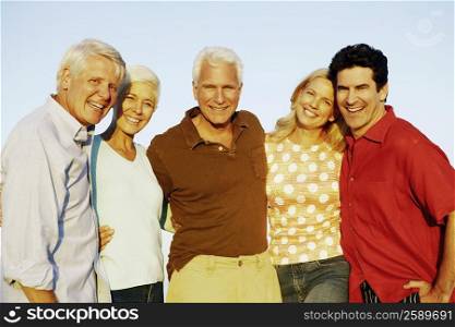 Portrait of three mature men and two mature women standing together and smiling