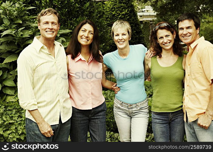 Portrait of three mature women and two mature men standing together and smiling