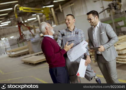 Portrait of three men standing and discuss in furniture factory