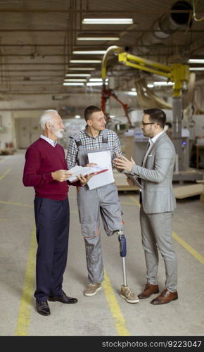 Portrait of three men standing and discuss in furniture factory