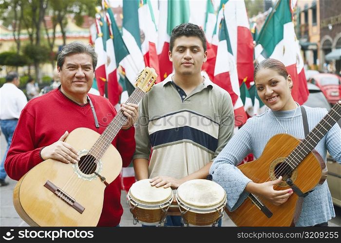Portrait of three musicians standing with their musical instruments