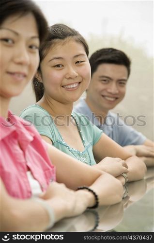 Portrait of three office workers sitting at a conference table and smiling